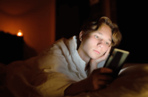 teen scrolling on their phone due to feeling depressed and needing teen therapy